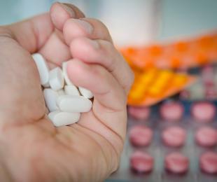 imagen de una mano cogiendo un puñado de pastillas