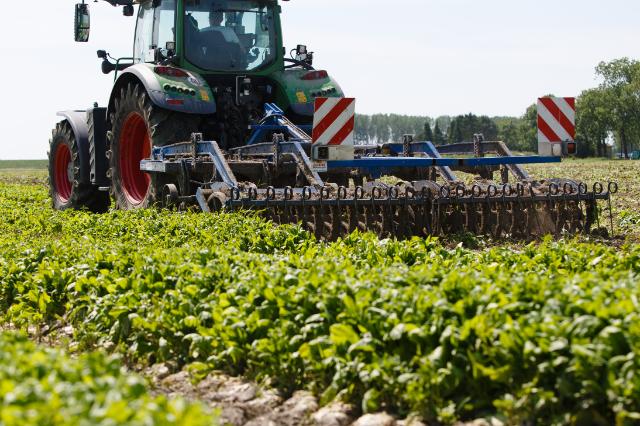 imagen de tractor con segadora en un campo cultivado
