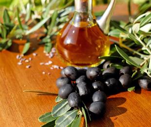 imagen de aceitunas negras junto con una jarra de aceite