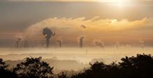 imagen de cielo con niebla y gases emergiendo de chimeneas industriales